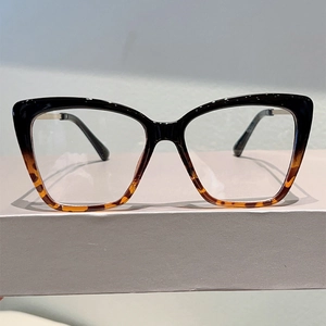 Vista dettagliata di occhiali cat-eye anti-luce blu con montatura sfumata nera e tartaruga