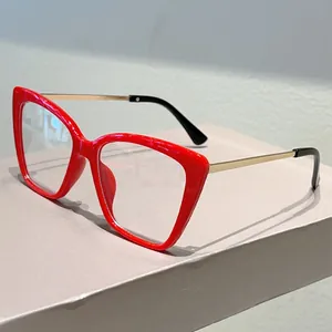 Dettaglio montatura cat-eye rossa con stanghette in metallo dorato e punte nere
