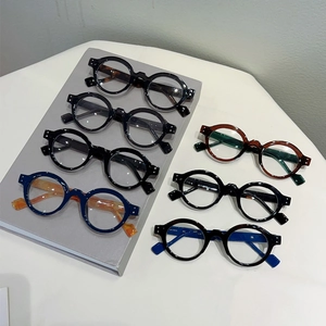 Vintage round frame anti-blue light glasses in various colors on a display stand