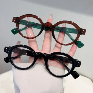 Detail of retro round glasses frames with rivet accents in black and brown finishes