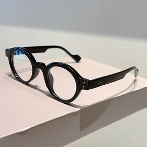 Macro view of retro black round frame glasses featuring decorative silver rivet accents