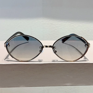Detail of gradient lenses and oval metal frame on stylish punk-inspired sunglasses