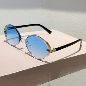Detailed view of oval metal sunglasses with blue gradient lenses and textured gold frames