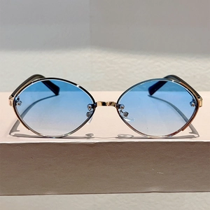 Detail of gold metal oval sunglasses with blue gradient lenses and slim frame design