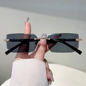 Fashionable rimless rectangular sunglasses with black lenses and gold metal accents