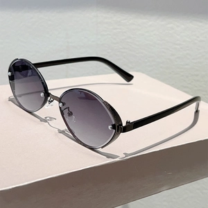 Macro view of rimless oval metal sunglasses with gradient lenses and silver rivet details