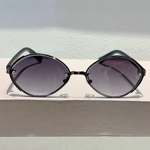 Detail of oval metal frame sunglasses with purple gradient lenses in punk style