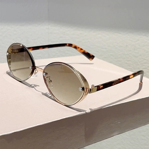 Detail of oval metal sunglasses with tortoise temple and brown gradient lenses