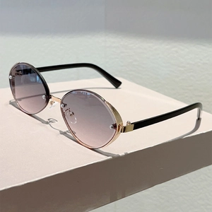 Detailed close-up of golden metal frames with grid texture on oval fashion sunglasses