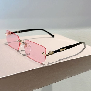 Detail view of rimless rectangle sunglasses with pink lenses and gold metal bridge