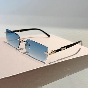 Detail of rimless rectangle sunglasses with blue gradient lenses and gold bridge