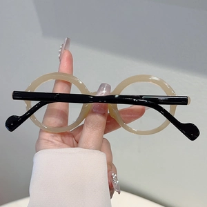 Detail view of round retro beige glasses frame with black temples for a vintage academic look