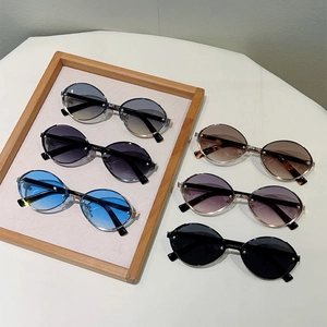 Set of six oval metal sunglasses with gradient lenses in various colors on wooden tray
