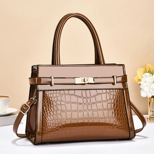 Detailed view of brown crocodile texture patent leather handbag with gold twist lock buckle