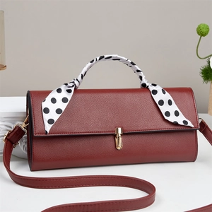 Reddish brown pebbled leather crossbody bag with polka dot scarf handle and gold lock