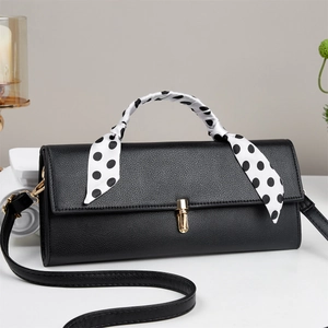 Classic black pebbled leather handbag with gold metal lock and polka dot silk scarf handle