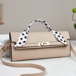 Elegant beige leather crossbody bag with silk scarf wrapped handle in a 45-degree side view