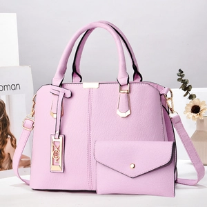 Detailaufnahme des rosa Kunstleder-Handtaschensets mit goldenen Beschlägen und Etui