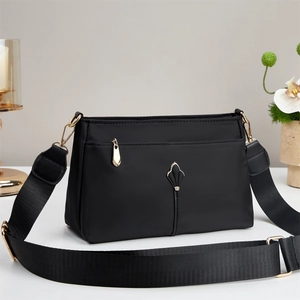 Chic black water-resistant nylon shoulder bag with adjustable strap and gold hardware