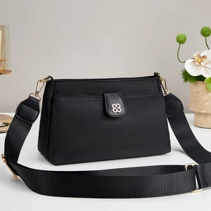 Fashionable black nylon shoulder bag for women with golden clover metal buckle detail
