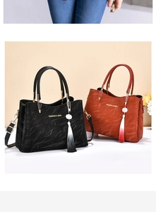 Detail of pleated leather texture on black and brown handbags with metal handles