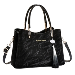 Elegant black pleated leather handbag with gold lettering and bicolor tassel pendant