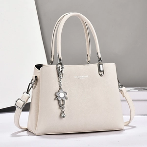 Sac à main chic en similicuir beige avec bandoulière et pendentif fleur élégant