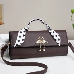 Détail du sac à main marron foncé avec foulard à pois et fermoir cygne doré perlé