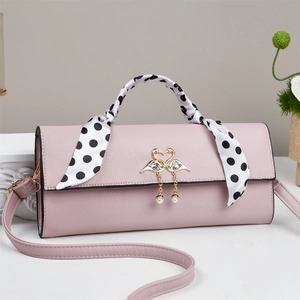 Détails du sac à main en cuir rose avec breloque cygne dorée et écharpe à pois élégante