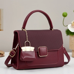 Deep wine red minimalist crossbody bag with woven texture and mini bag charm accessory