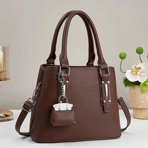 Classic dark brown lychee leather tote bag with silver hardware and a mini charm accessory