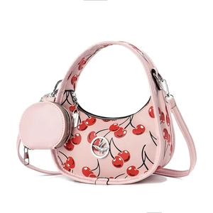 Pink crescent shoulder bag with red cherry prints and matching round coin purse charm
