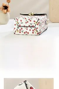 Detail view of mini bucket bag showing cherry print and golden anti-wear base studs