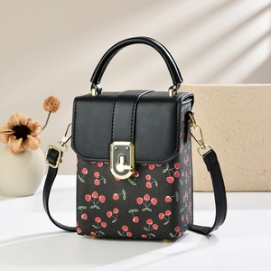 Chic black mini crossbody bag with red cherry print and golden metal clasp closure
