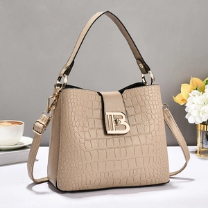 Detail view of beige crocodile embossed bucket bag featuring elegant TB gold buckle