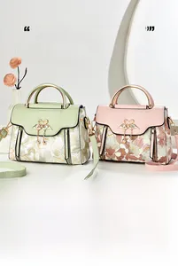 Detail of minimalist tote bags featuring floral patterns and gold swan pearl pendants