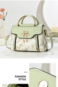 Detail of floral embroidery, golden swan clasp, and pearl charms on green handbag
