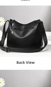 Vue arrière du sac bandoulière en cuir noir montrant les fermetures éclair et la poche