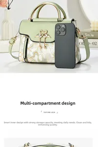 Detail of light green crossbody bag with floral embroidery and swan metal clasp