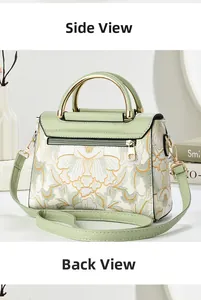 Detail view of light green floral embroidery on handbag with golden handle and back zipper pocket