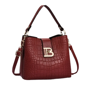 Burgundy crocodile embossed handbag with gold B hardware and adjustable strap