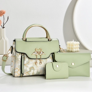 Three-piece sage green handbag set with floral fabric and swan buckle in elegant lifestyle setting