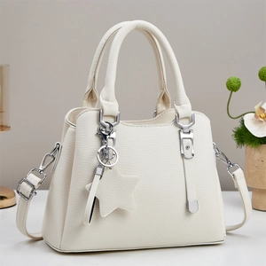Detail of white lychee pattern leather tote bag with star charm and silver hardware