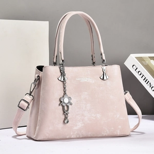 Elegant pink synthetic leather tote bag with silver hardware and a floral pendant