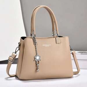 Schicke beige Tragetasche aus Leder mit Narbenstruktur, Blumenanhänger und Tragegurt