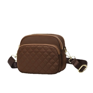 Deep brown quilted nylon crossbody bag with three zippers and golden hardware