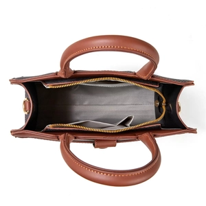 Detailed interior view of a brown leather bucket bag showing herringbone lining and pocket