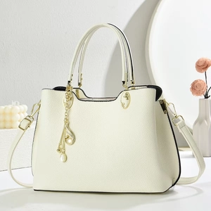 Detail of off-white lychee texture leather handbag with gold pearl charms and strap