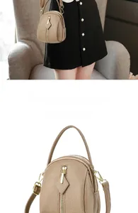 Detail of khaki pebbled leather crossbody bag with dual zippers and gold hardware