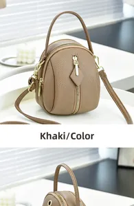Detail view of khaki pebbled leather crossbody bag with multiple zipper compartments